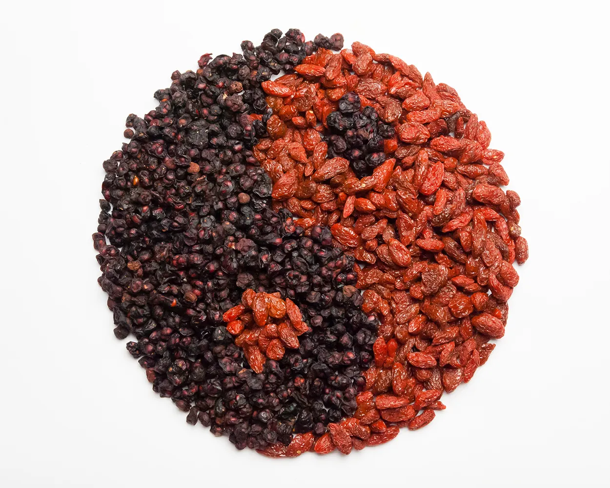 Goji berries and schisandra berries arranged in a yin-yang circle