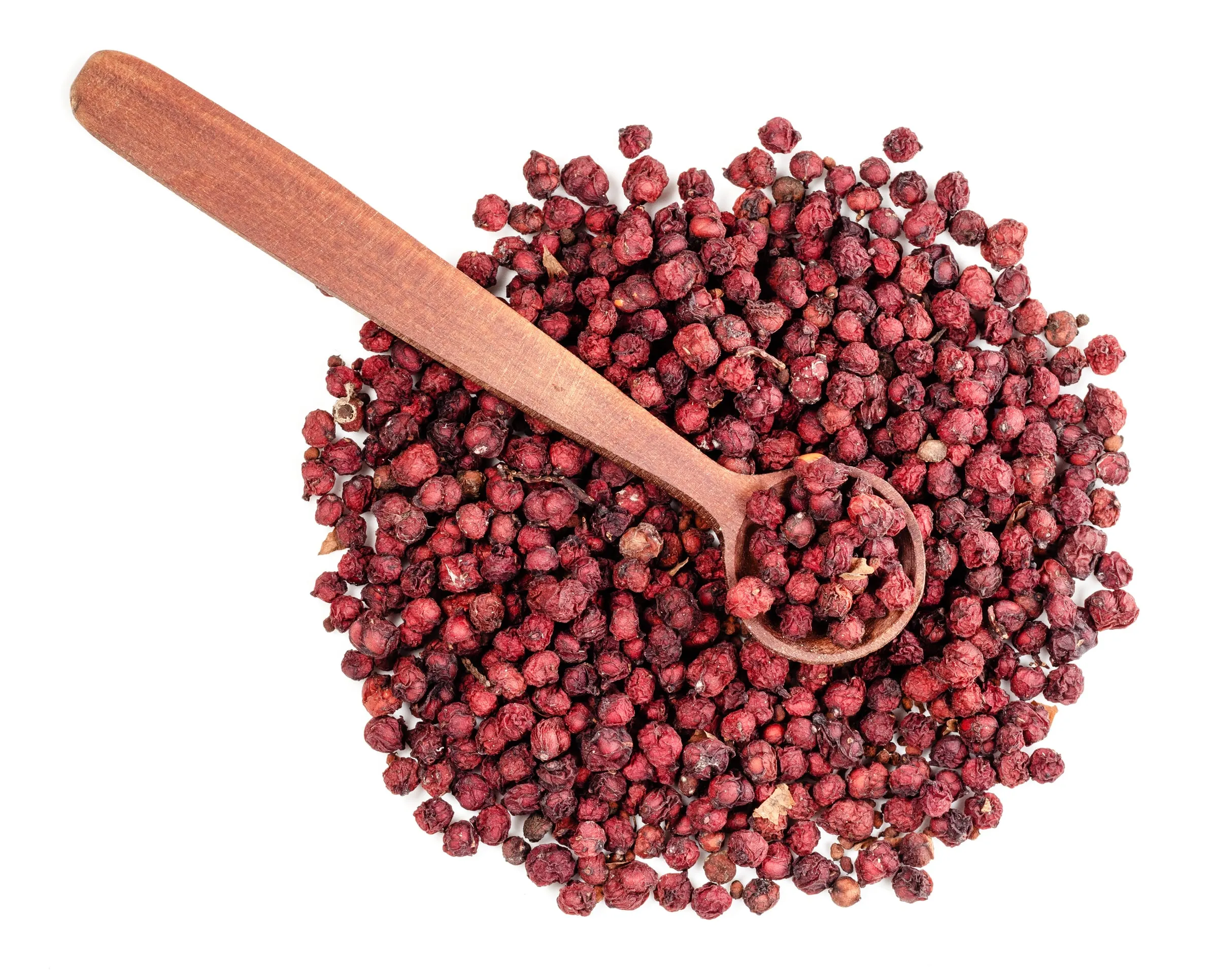 Dried schisandra berries with a wooden spoon