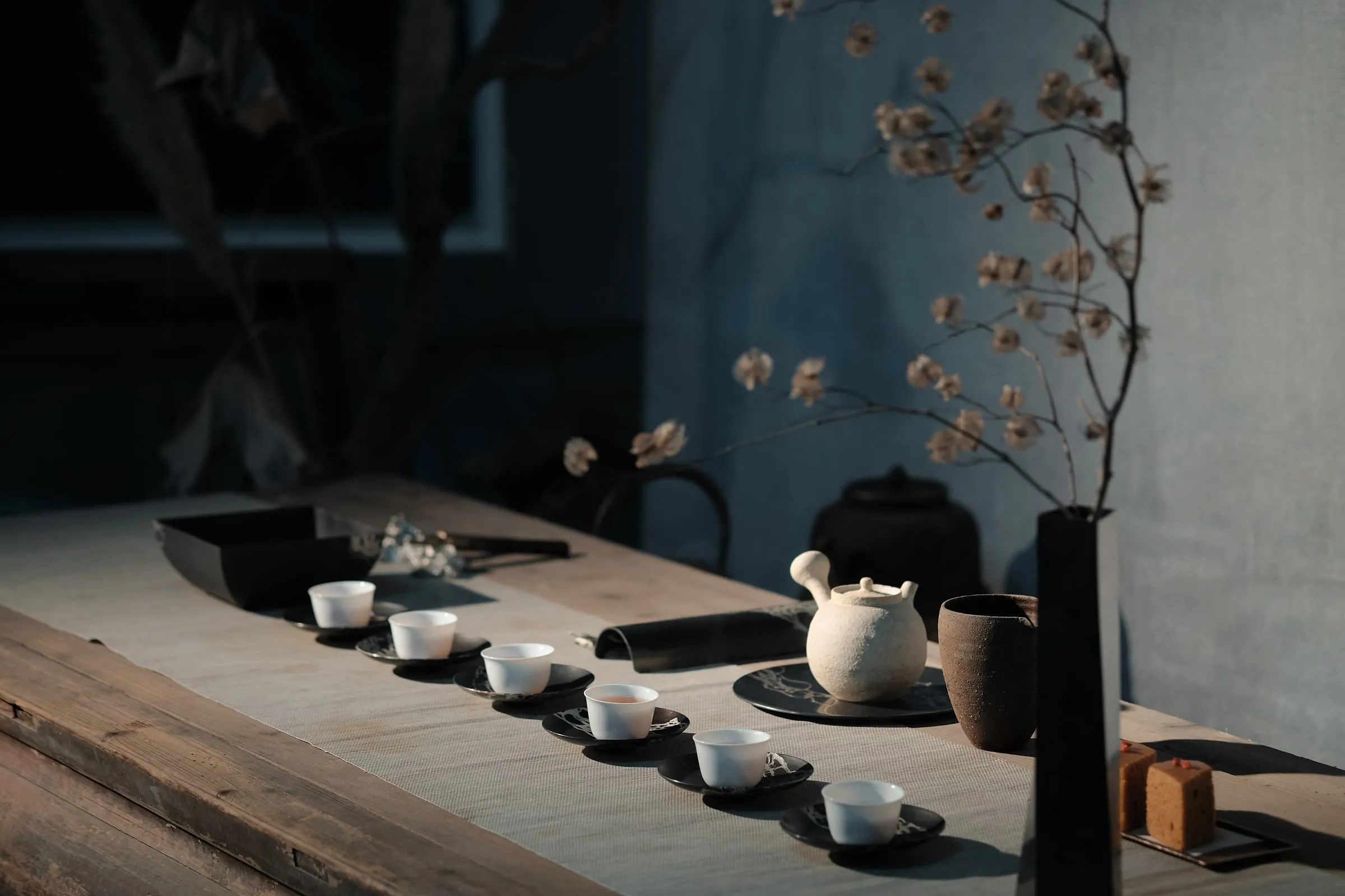 A traditional Chinese tea set laid out on a long wooden table