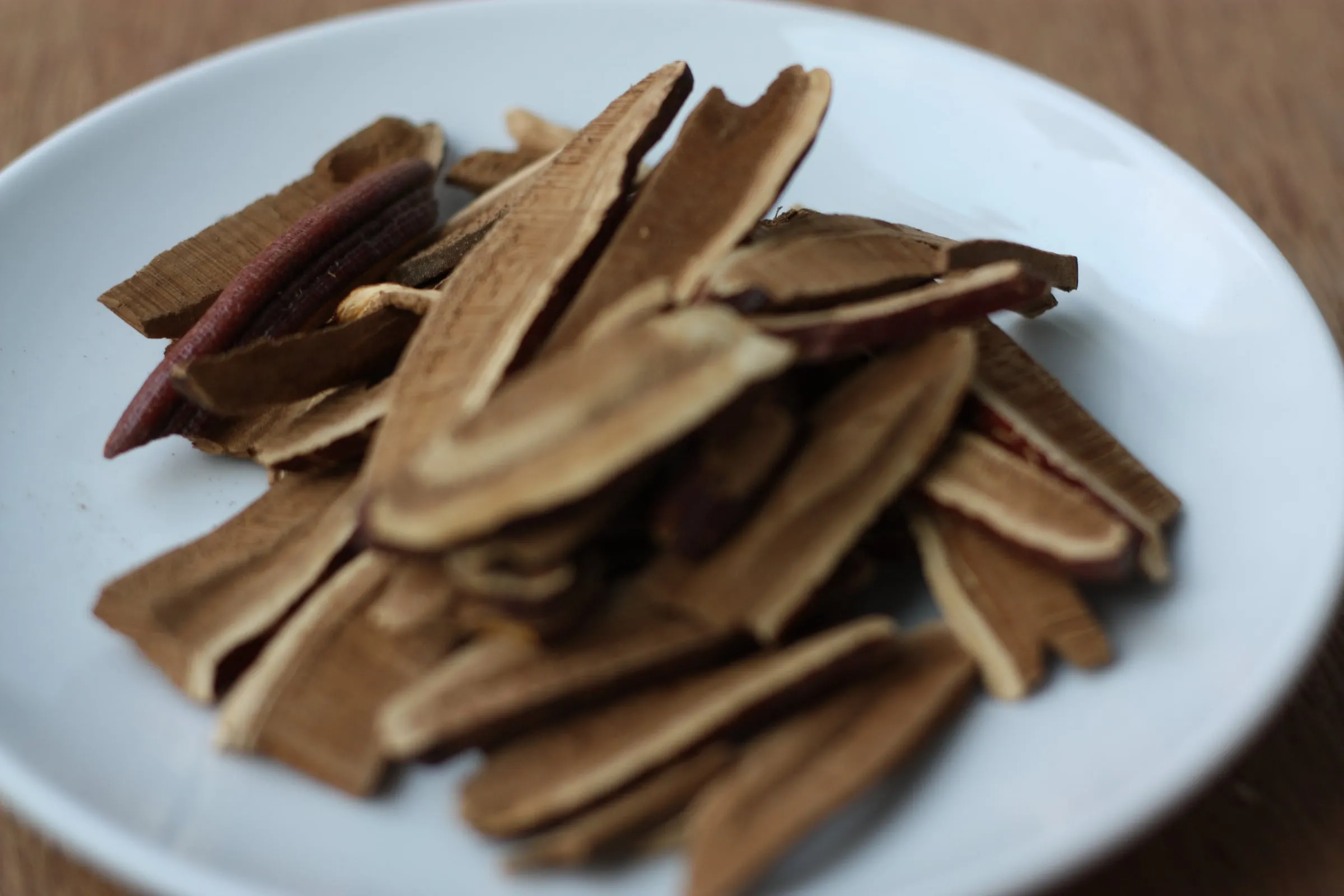 Slices of dried reishi mushroom on a white plate